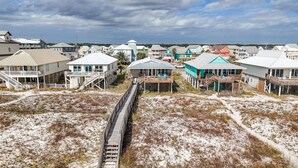 A coastal residential area with houses connected by a wooden boardwalk.