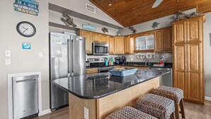 A modern kitchen with wooden cabinets, stainless steel appliances, and a granite countertop.