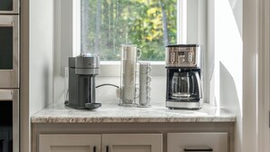 Una encimera de cocina con cafetera, dispensador de agua y jarra de café.