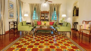 Una habitación con sofá verde, una mesa de centro de madera y piso con diseño.