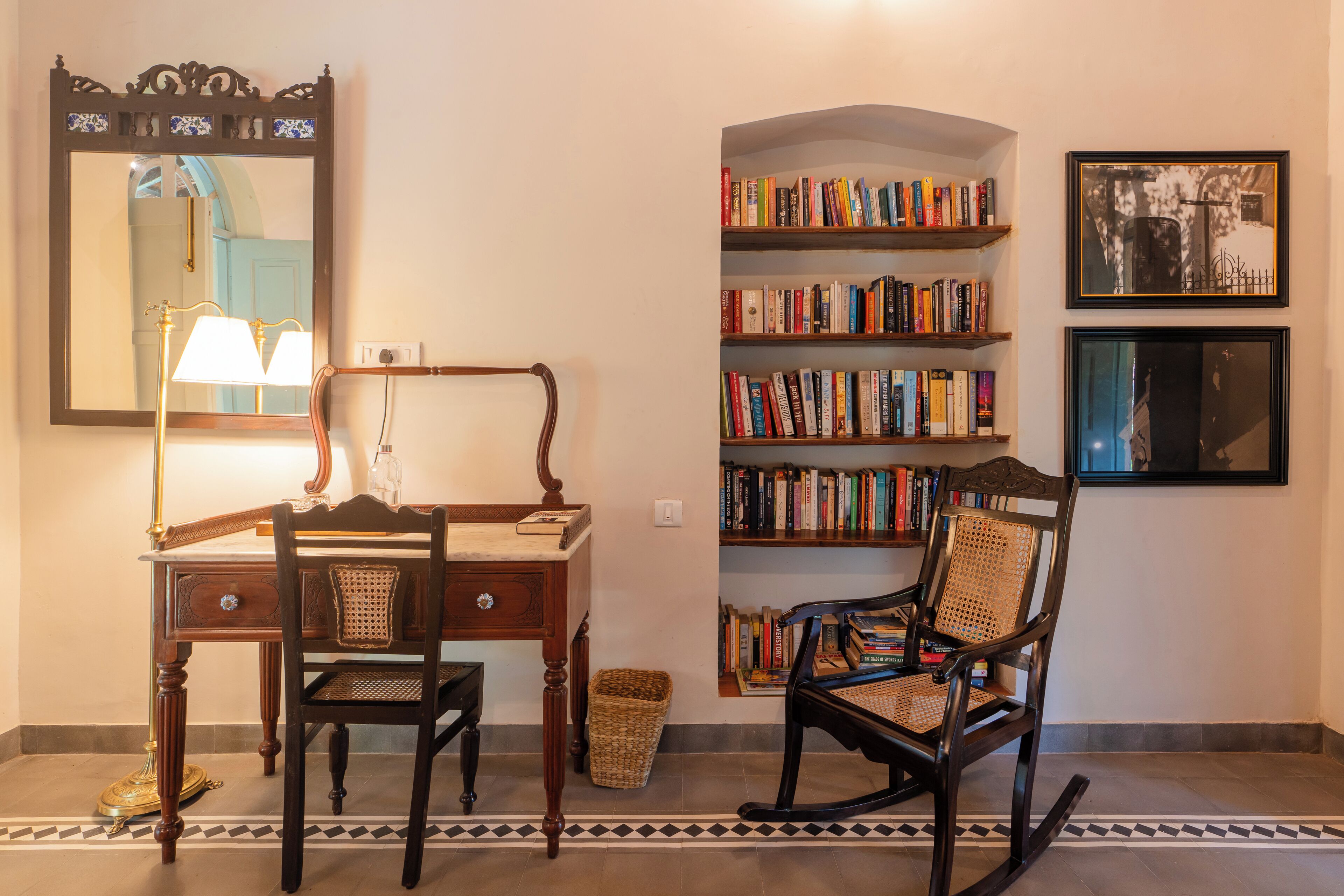 Um quarto com uma escrivaninha de madeira, uma cadeira, uma estante de livros e um quadro na parede.
