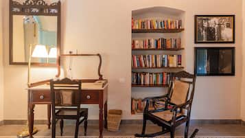Um quarto com uma escrivaninha de madeira, uma cadeira, uma estante de livros e um quadro na parede.