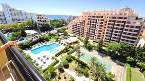 Un hôtel de grande hauteur doté de nombreux balcons, d’une piscine et de jardins aménagés.