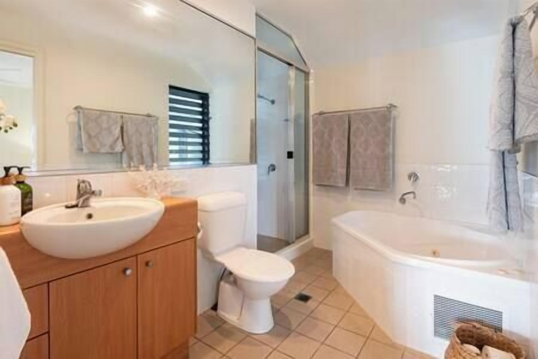 A modern bathroom with a sink, toilet, and shower.