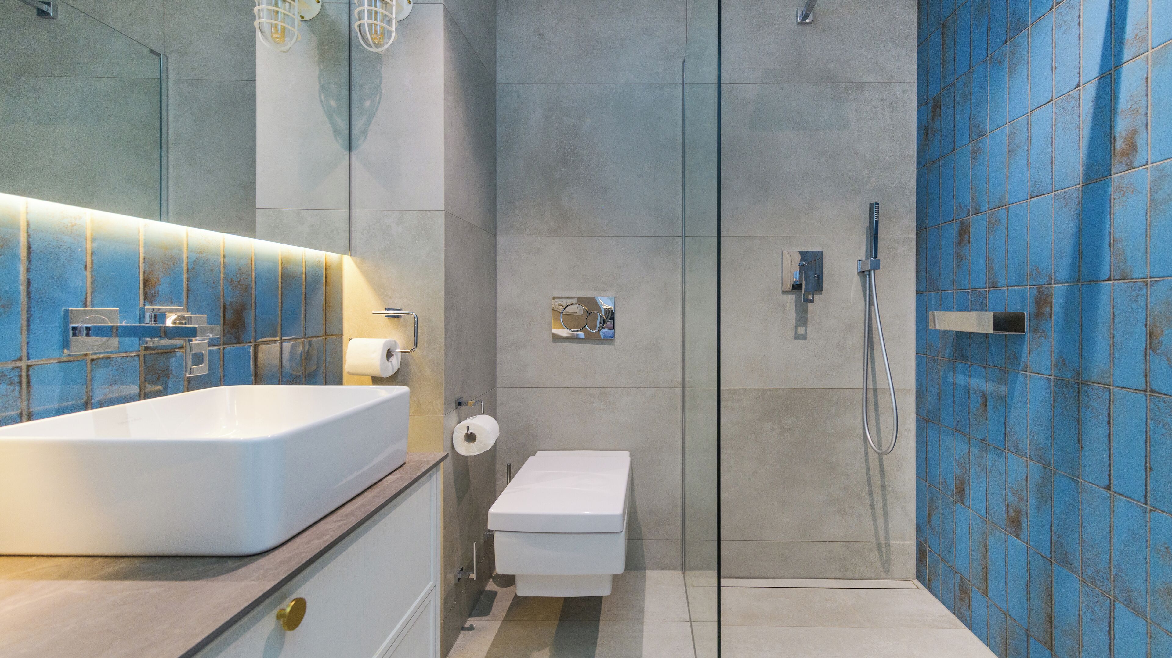 A modern bathroom with a large white bathtub, a toilet, and a glass-enclosed shower area.