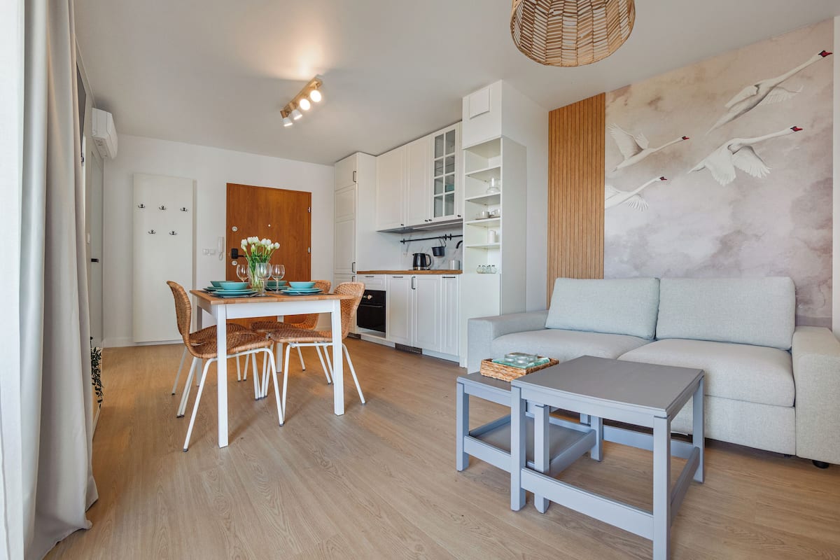 Un salon moderne comprenant un canapé, une table à manger avec des chaises et un coin cuisine.