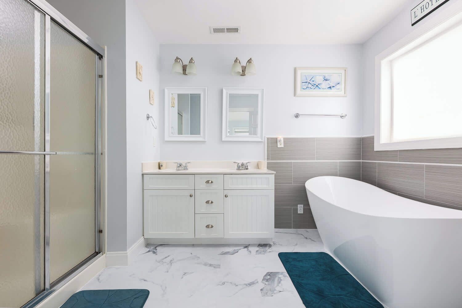 A modern bathroom with a walk-in shower, a freestanding bathtub, and a vanity with a mirror.