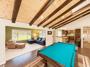 A spacious living area with a pool table, a sectional sofa, and a view of the backyard. - Skyland 3 BR, access to private beach, BBQ, Hot Tub, Pool Table (ZC1004) (Zephyr Cove)