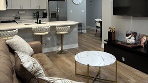 Una sala de estar moderna con un sofá, una mesa de centro y un televisor.