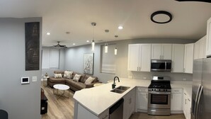 Una cocina moderna con armarios blancos, electrodomésticos de acero inoxidable y una isla central.