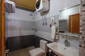 Un baño con inodoro, lavamanos y ducha.