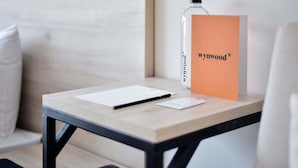A wooden table with a white notepad, a pen, and a clear bottle. An orange sign with the text "wynwood" is visible.