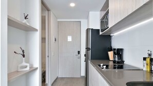 A modern kitchen with a stainless steel refrigerator, a coffee maker, and a sink.