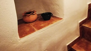 A small alcove with a white wall and a window, containing a terracotta pot and a black bowl. - Authentic White House in Paros Lefkes (Paros)
