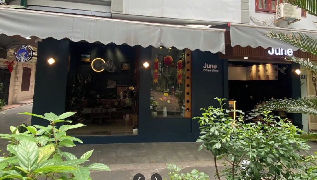 Fachada oscura con un letrero que dice 'June Coffee Shop'.