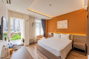 Une chambre d’hôtel avec un lit, une table de chevet, une chaise et une vue sur le paysage urbain.