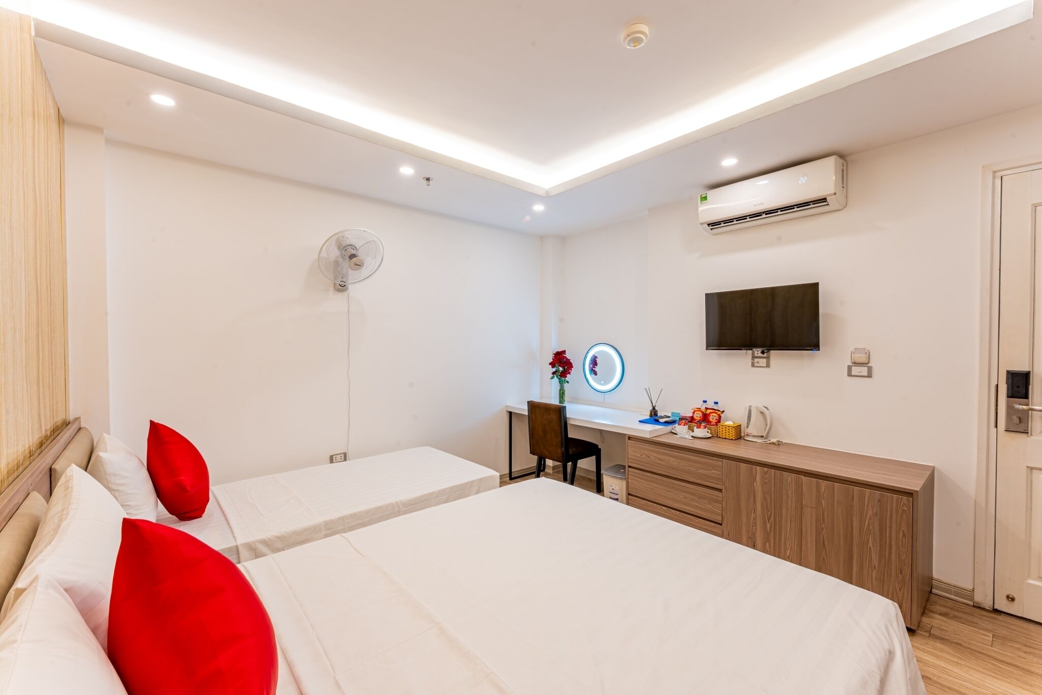 Une chambre d’hôtel équipée d’un lit, d’un bureau, d’une chaise, d’une télévision et d’un appareil de climatisation.