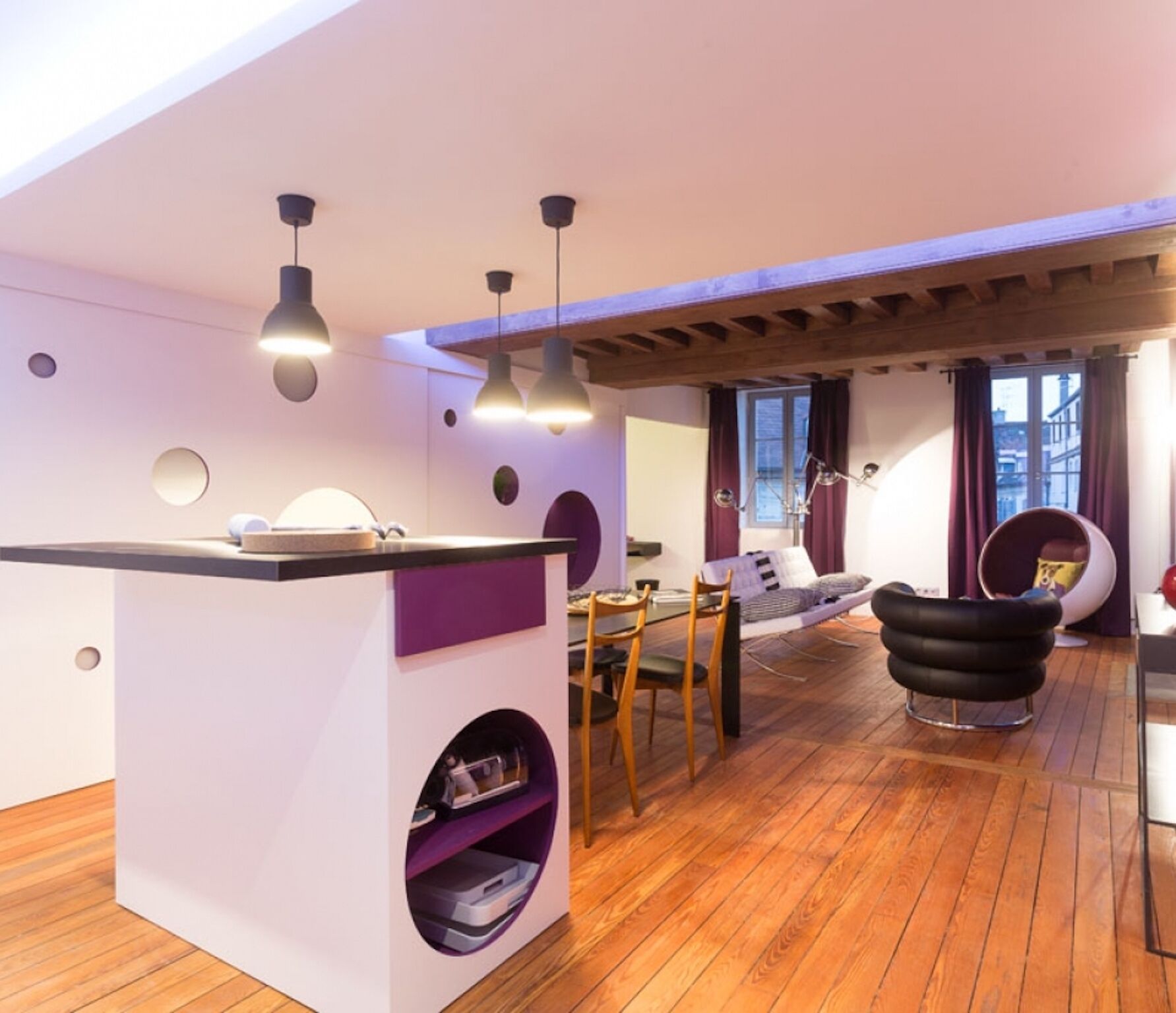 A modern living space with a kitchen area, dining table, and seating area.