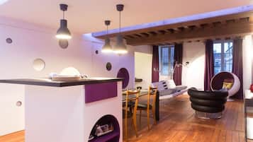 A modern living space with a kitchen area, dining table, and seating area.