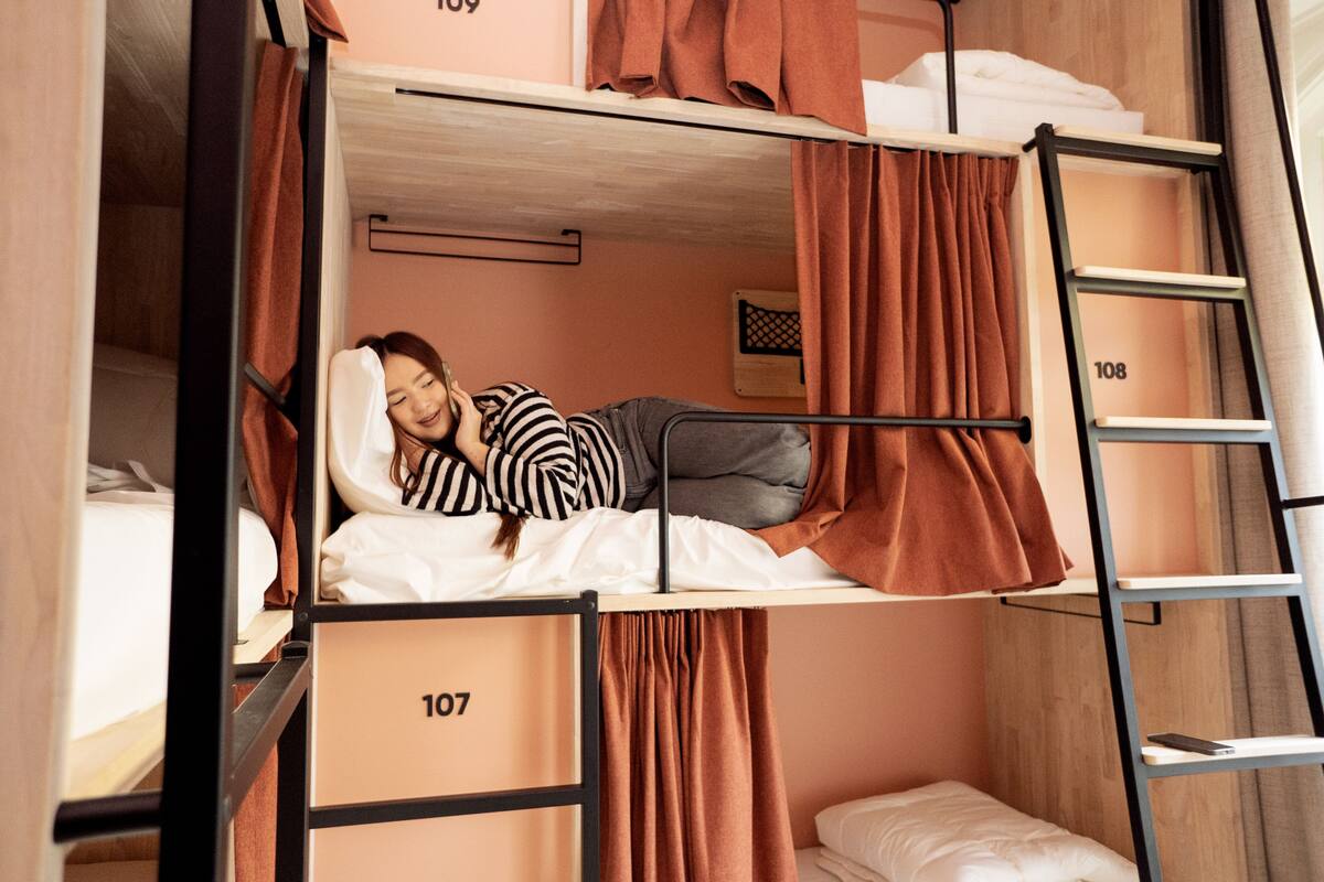 A bunk bed room with a ladder, numbered 107 and 108, and a small bedside table.