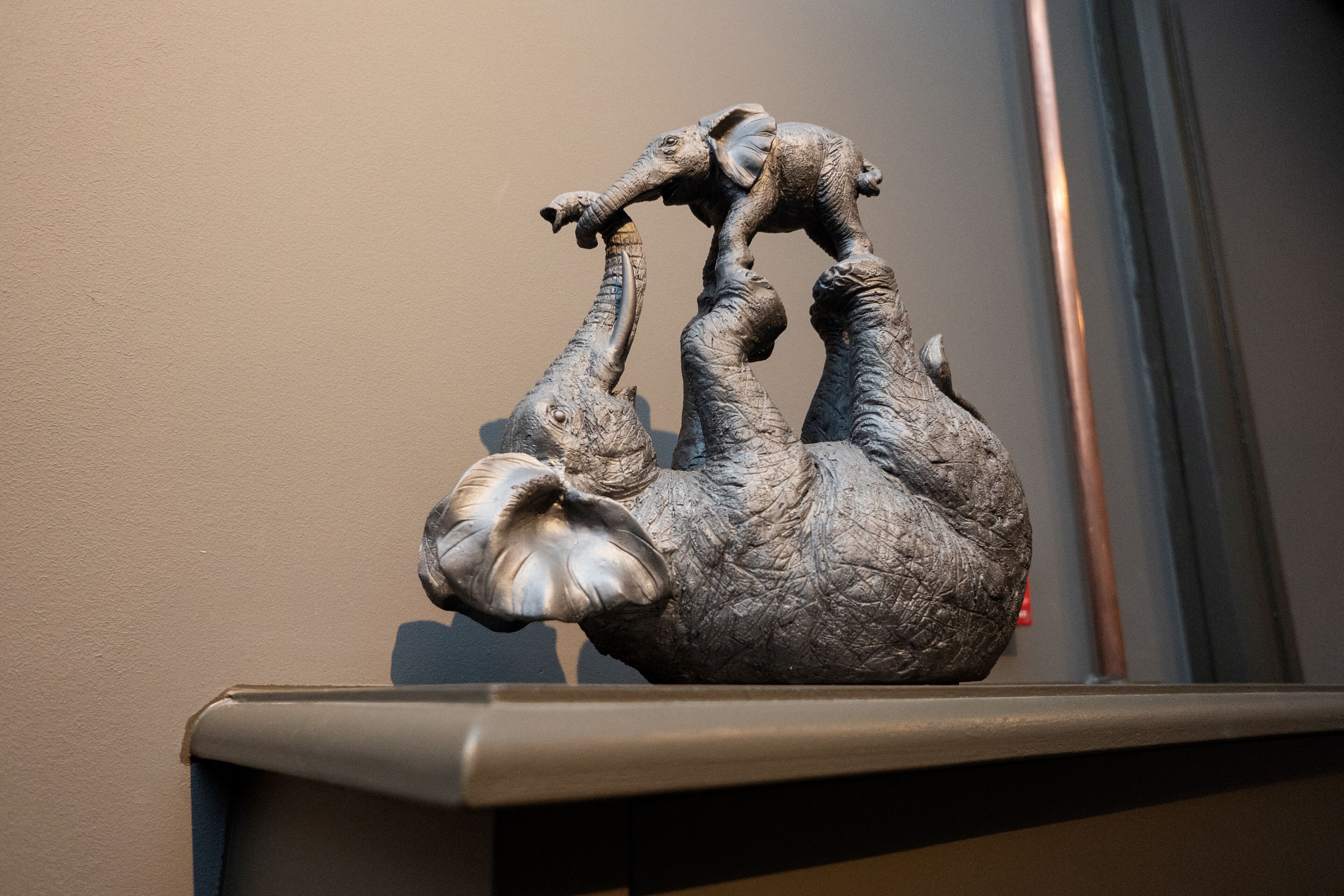 Una escultura de un elefante sobre una estantería.