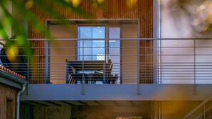 Un bâtiment moderne doté d’un balcon avec une table et des chaises.