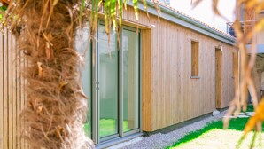 Un bâtiment moderne avec un revêtement en bois, de grandes portes-fenêtres coulissantes et une petite fenêtre.