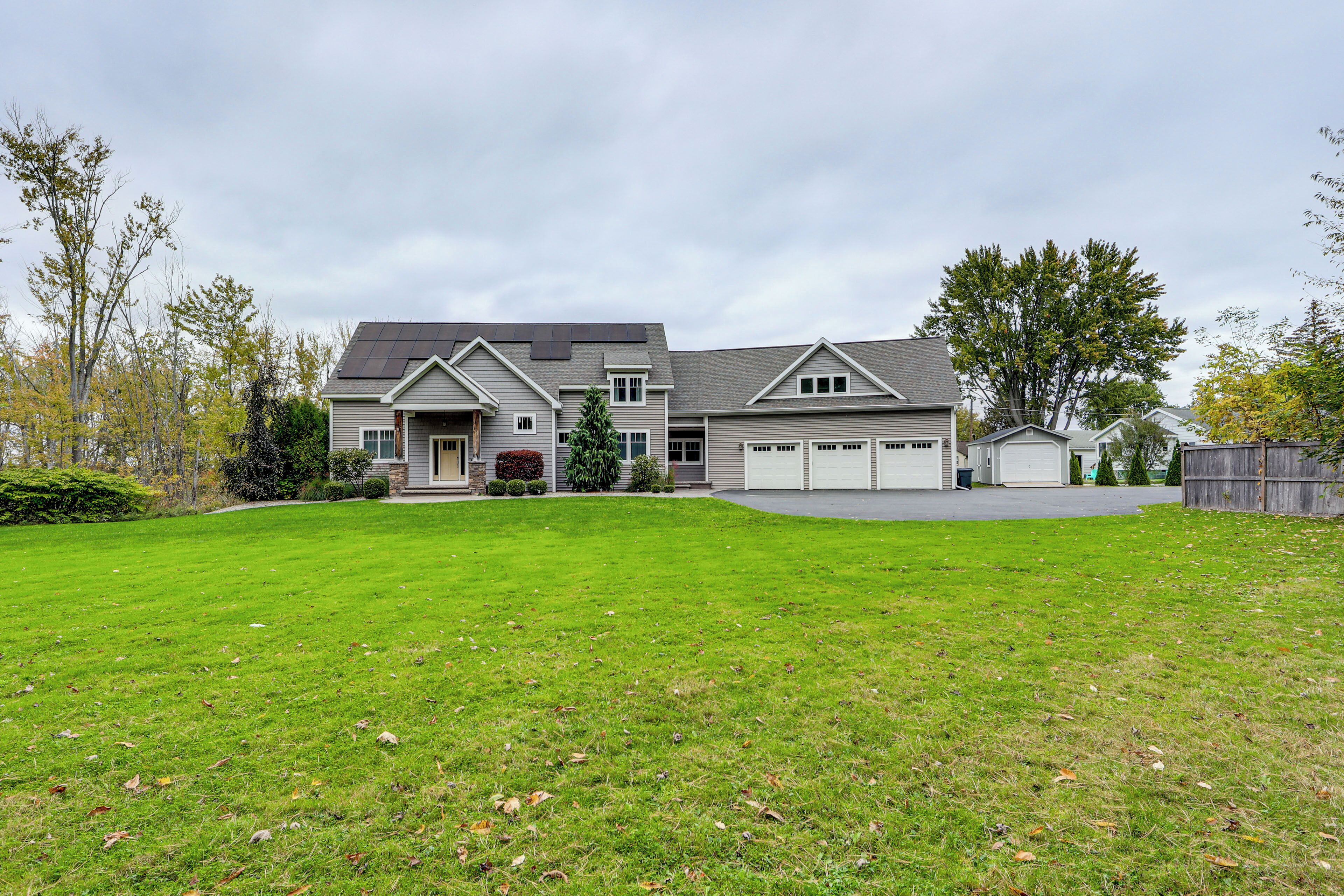 A two-story house with a large front lawn, garage, and a well-maintained garden.
