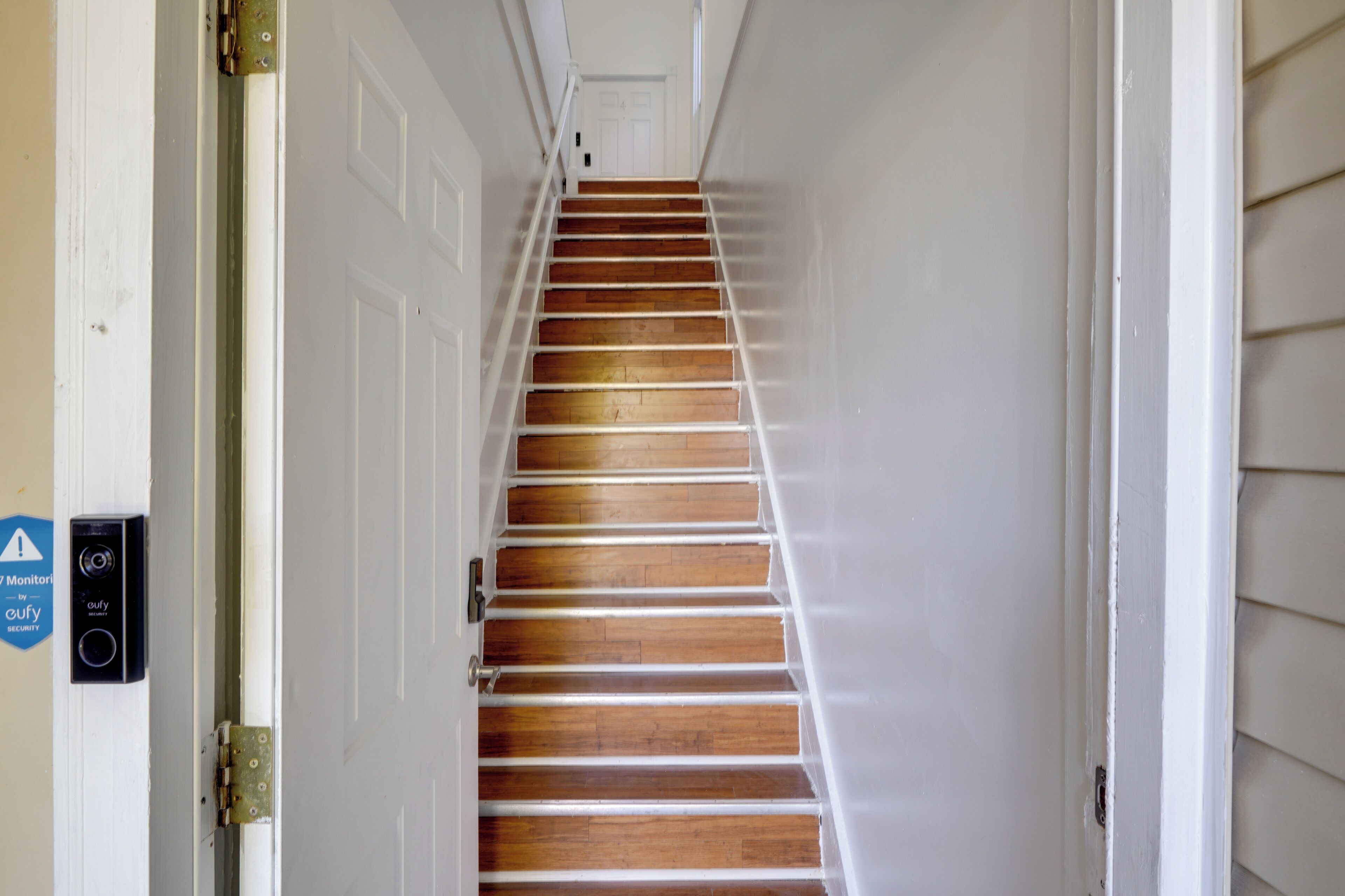 A staircase with wooden steps and white walls.