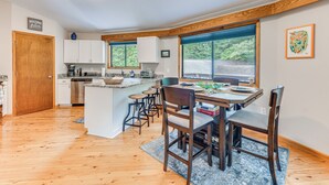 Une cuisine moderne dotée d’un îlot central, de tabourets de bar et d’une table à manger.