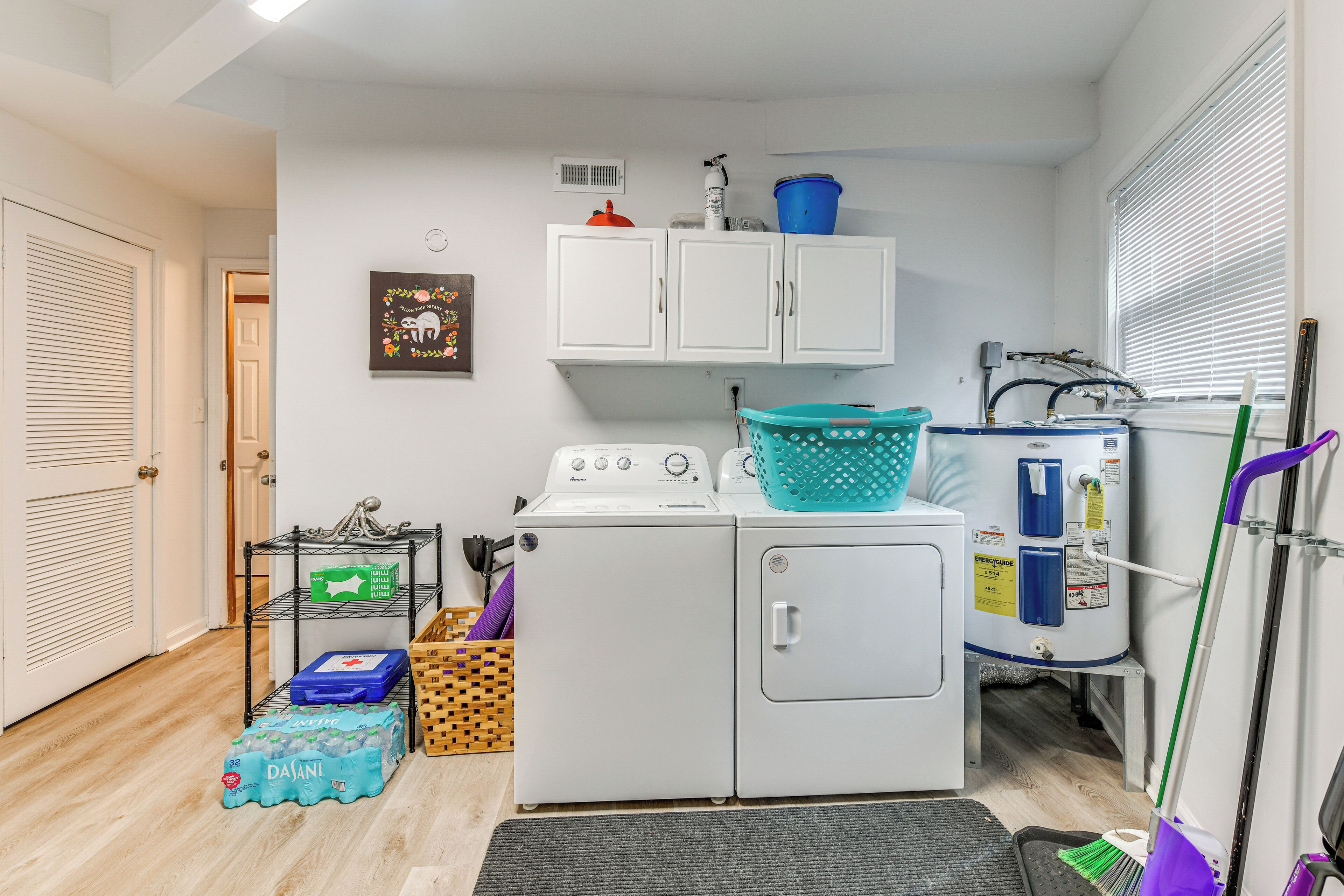 A laundry room with a washing machine, dryer, and stacked laundry baskets.