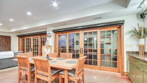 A spacious dining area with a wooden table and chairs, a sofa, and a kitchen area with cabinets and a countertop. - Scenic Getaway w/ Fire Pit & Grill in Columbia! (Columbia)