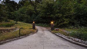 A paved pathway leading to a gated entrance surrounded by greenery. - Scenic Getaway w/ Fire Pit & Grill in Columbia! (Columbia)