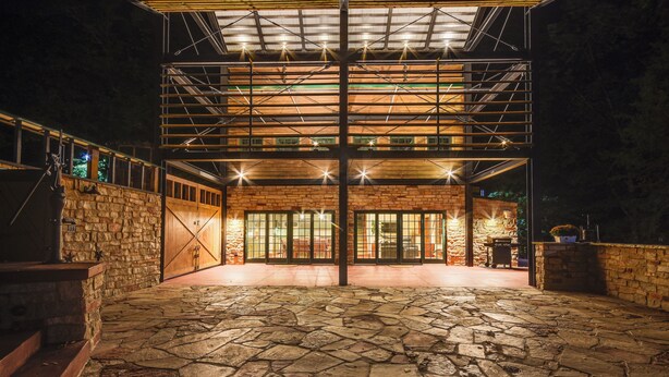 A building with a stone facade, large glass doors, and a covered outdoor area with stone flooring. - Scenic Getaway w/ Fire Pit & Grill in Columbia! (Columbia)