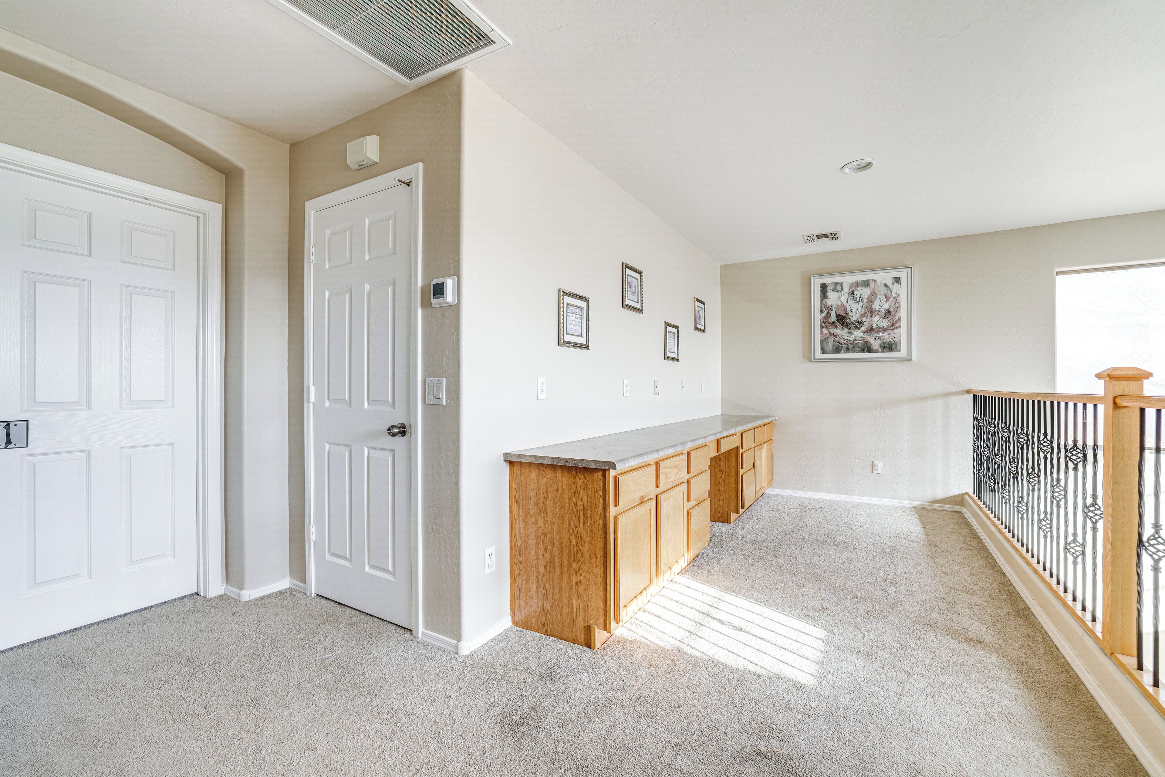 A hallway with a wooden bench, white doors, and a picture on the wall.