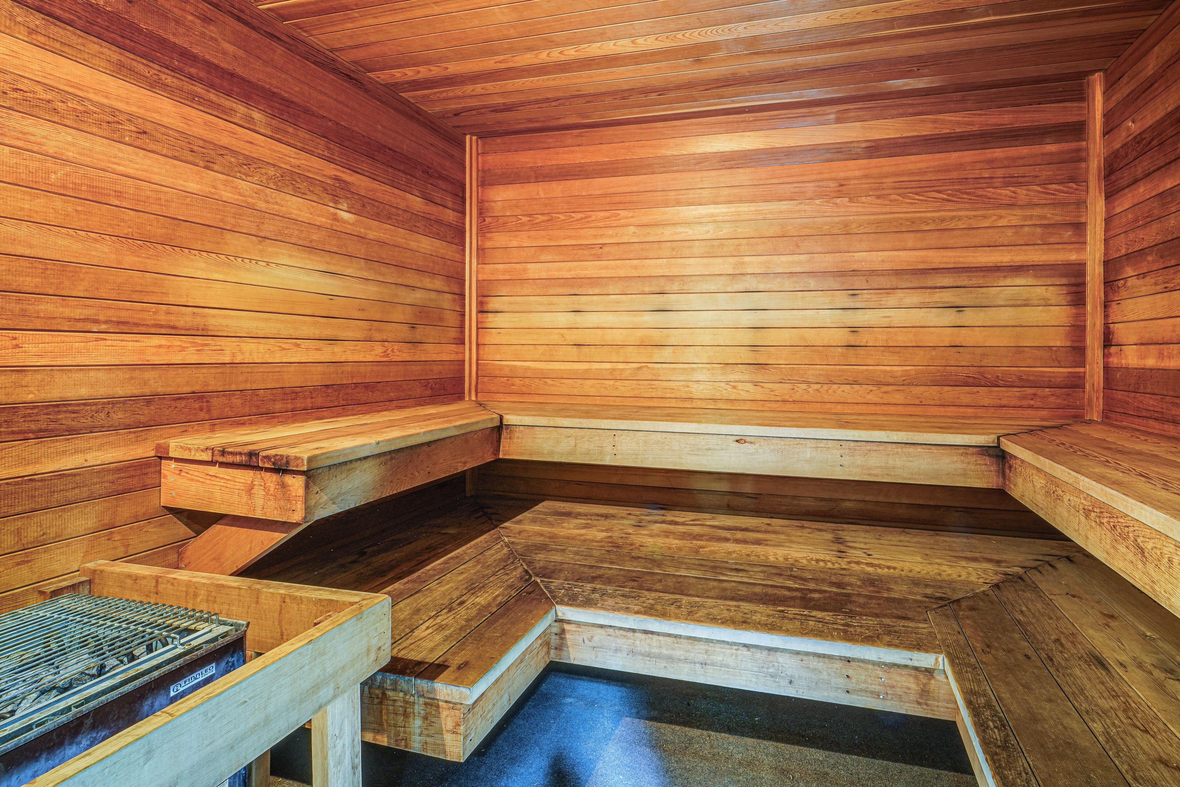 Un sauna en bois avec des bancs et une banquette.