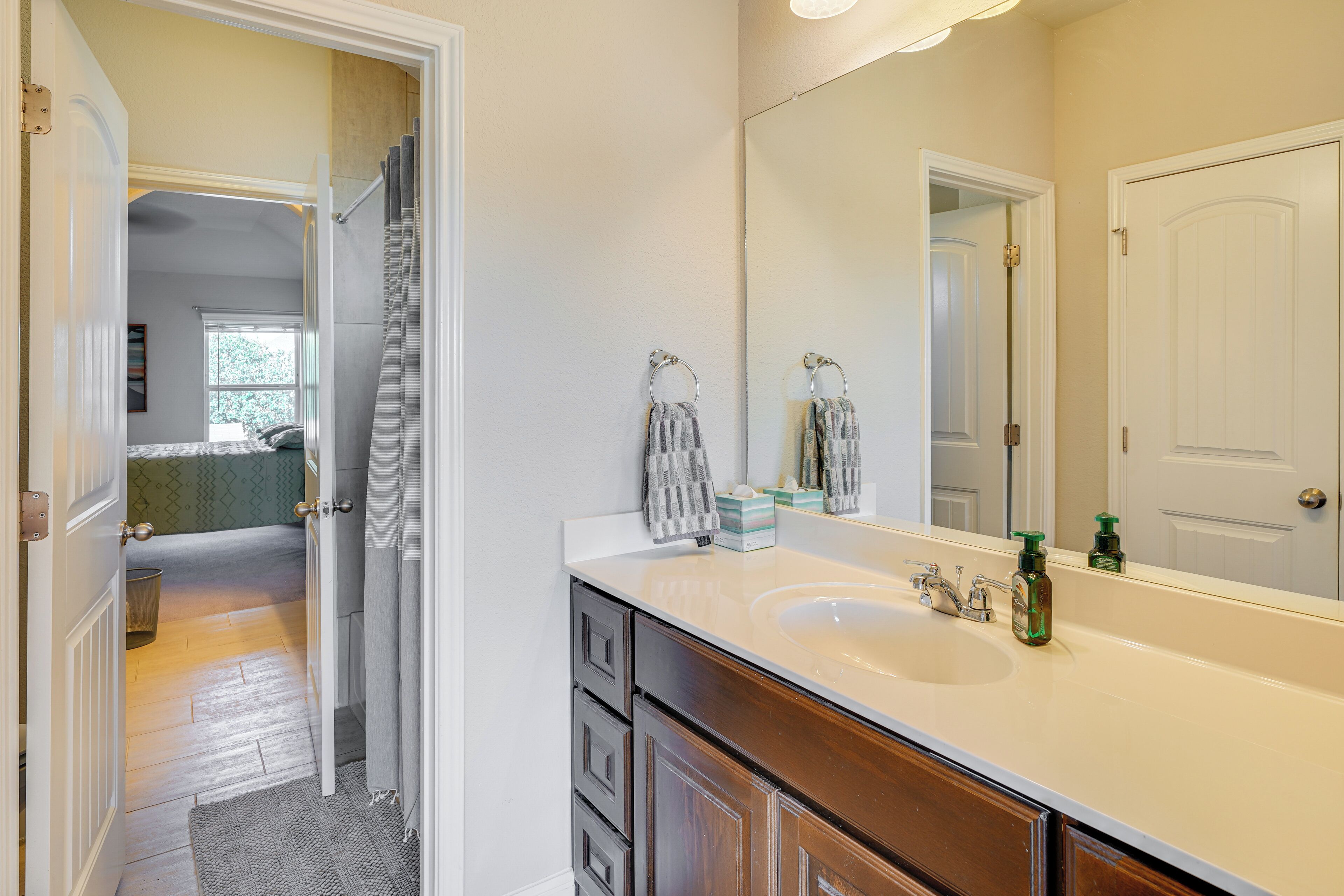 Une salle de bain avec un grand miroir, un lavabo et une douche.