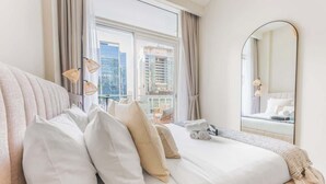 Een hotelkamer met een groot bed, een spiegel en uitzicht op de stad.