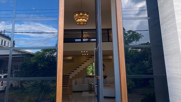 A modern building entrance with a glass facade, a central door, and a staircase leading to an upper level. - Empire Villa 2 Mon Plaisir (Paramaribo)