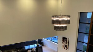 A spacious living area with a large sectional sofa, a dining table with chairs, and a modern chandelier. - Empire Villa 2 Mon Plaisir (Paramaribo)