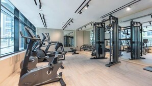 Una palestra moderna con macchinari cardio, attrezzature per sollevamento pesi e specchi.