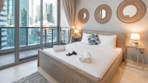 Ein modernes Hotelzimmer mit einem großen Bett, zwei Nachttischen mit Lampen, Blick auf die Stadt durch raumhohe Fenster und dekorative Wandspiegel.