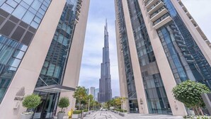 A modern building with a prominent central tower, surrounded by other high-rise structures.