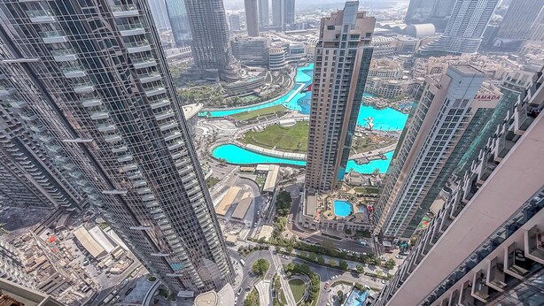 A high-rise building with a pool area surrounded by other high-rise buildings.