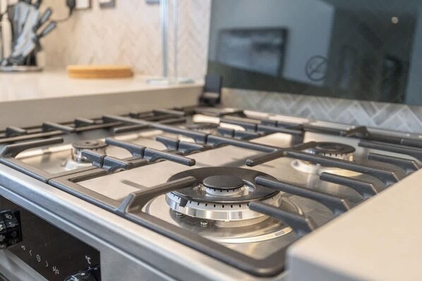 A kitchen with a gas stove, a microwave, and a coffee maker on the countertop.