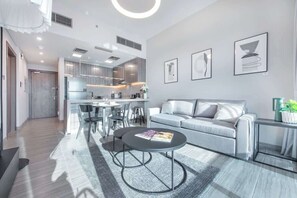A modern living room with a sofa, coffee table, and artwork on the wall.