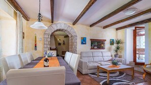 A dining area with a table set for four, a sofa, and a coffee table. - Villa Prisedi in Rakalj (Rakalj)