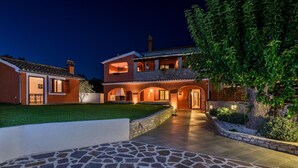 A two-story house with a stone pathway leading to the entrance, surrounded by greenery. - Villa Prisedi in Rakalj (Rakalj)