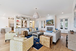 A modern living room with a sofa set, coffee table, and a fireplace. - Sunset Peak sleeps 12 with a pool (St Simons Island)