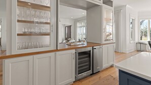 A modern kitchen with white cabinetry, a wooden countertop, and a built-in oven. - Sunset Peak sleeps 12 with a pool (St Simons Island)